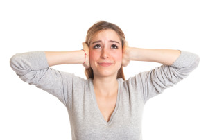 Young woman with long hair hates loud noise on an isolated white background for cutout