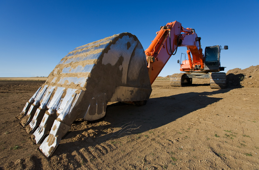 A large orange backhoe parked at a construction site